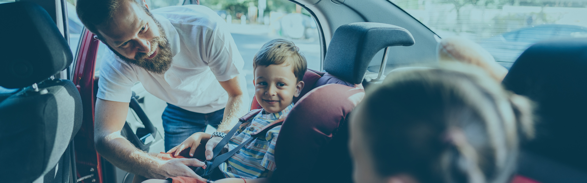 Father buckling children into car seats - All Rates
